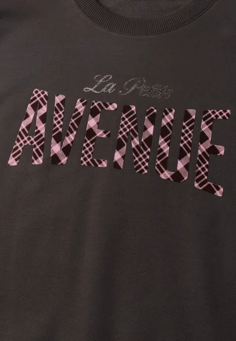 T-shirt sombre avec lettrage rose à motif 'La Plus AVENUE'.