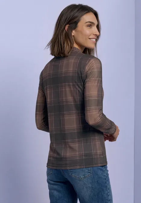 T-shirt à manches longues en mesh, col rond et imprimé sanded amber Frau trägt kariertes Langarmshirt und Jeans, steht vor hellem Hintergrund, von hinten.