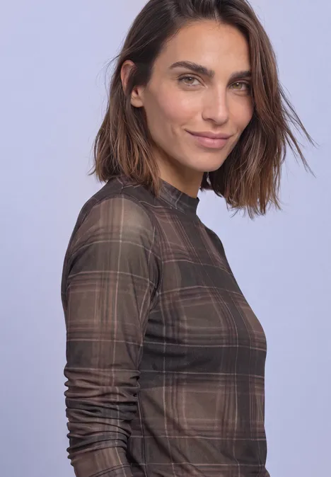 T-shirt à manches longues en mesh, col rond et imprimé sanded amber Eine Frau mit braun kariertem, halbtransparentem Langarmoberteil vor hellem Hintergrund.