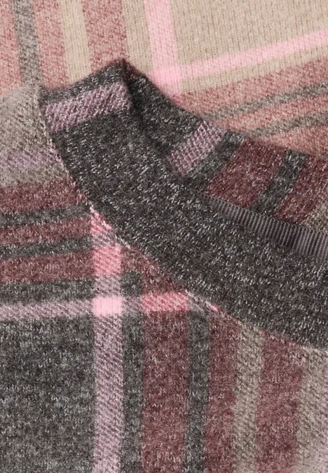 Graue Wollsocke auf karierter Decke in Rosa- und Grautönen.