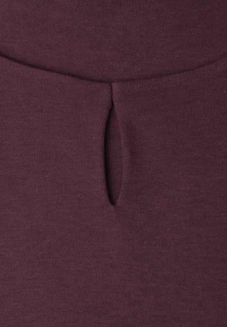 Gros plan sur un tissu bordeaux avec une petite fente verticale