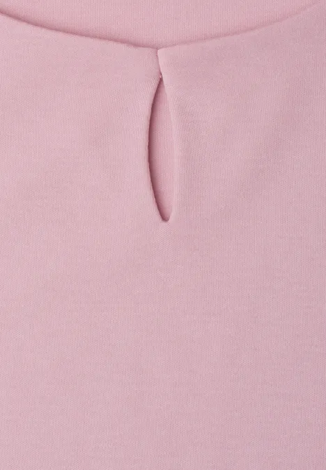 Nahaufnahme eines rosa Oberteils mit kleinem Schlitz am Rundhalsausschnitt.