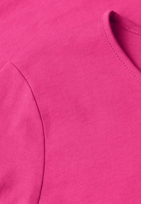 Detailaufnahme eines pinken T-Shirts aus weichem Stoff.