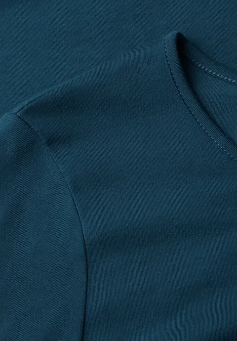 T-shirt basique à manches longues, couleur unie blue petrol Dunkeltürkises T-Shirt aus Baumwollstoff, Detailaufnahme von Ärmel und Halsausschnitt.