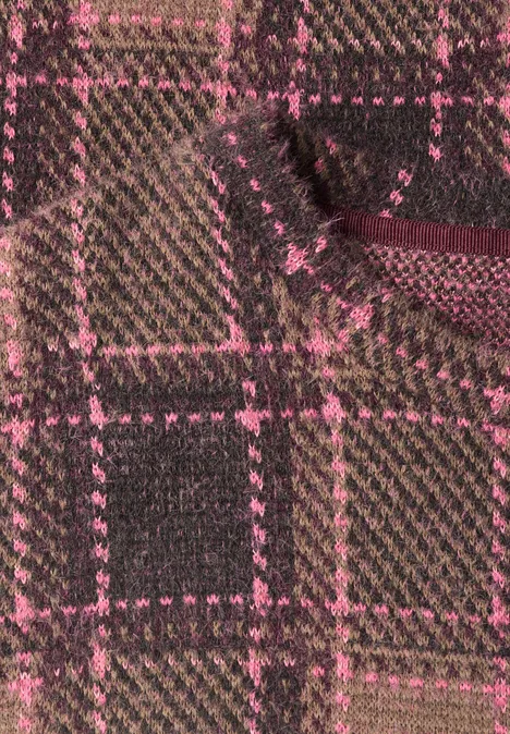 Gros plan sur un tissu à carreaux marron et rose, avec texture apparente et plis.