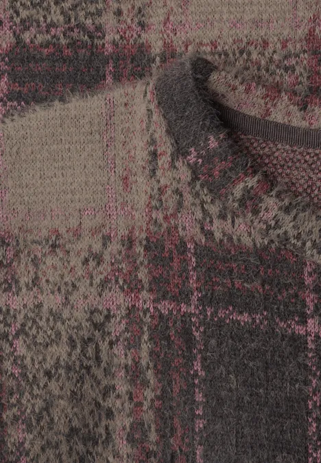 Gros plan d'un tissu texturé en laine à motif carreaux marron et rouge foncé.