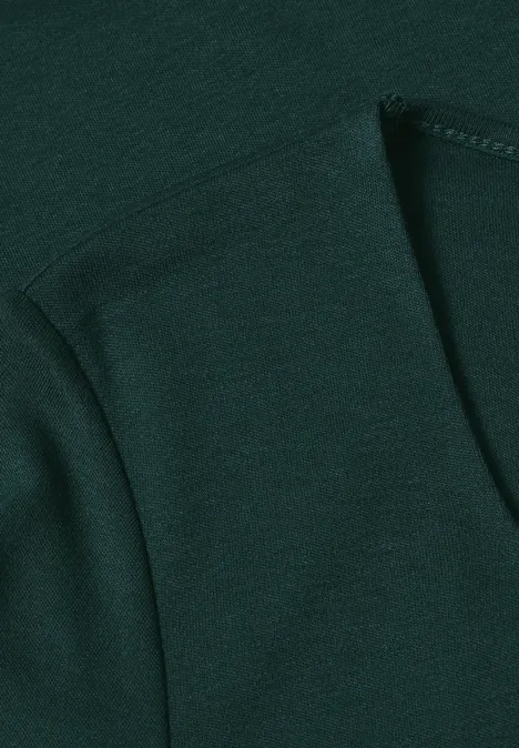 Gros plan sur un tissu vert foncé avec couture apparente