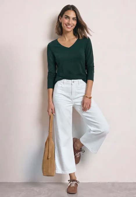 Langarm Shirt mit Carré Ausschnitt shadow teal Frau mit grünem Langarmshirt und weißen, weiten Culottes, trägt braune Ballerinas und eine beige Tasche.