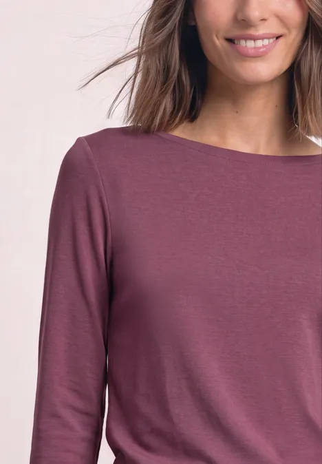 Koszulka z długim rękawem i dekoltem w kształcie łódki podwodnej dark clouded blush Kobieta nosi śliwkowy, długorękawowy top z dekoltem łódka.