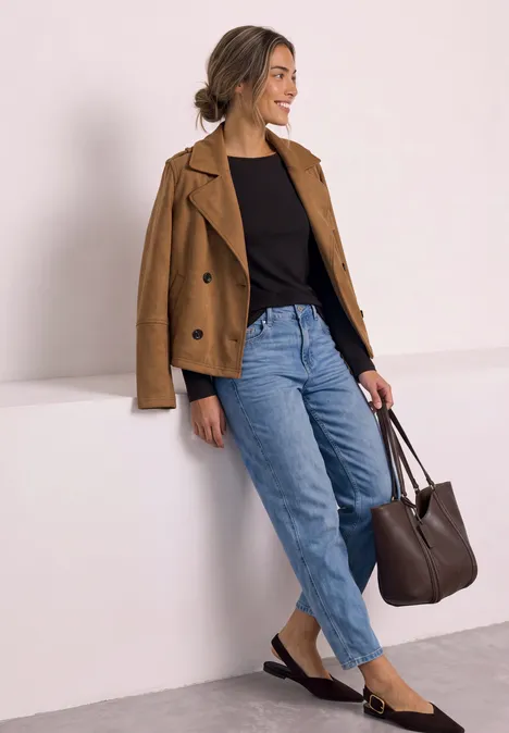 Langarm Shirt mit U-Boot-Ausschnitt black coffee Eine Frau in lässiger Kleidung mit brauner Jacke, schwarzem Shirt, Jeans und Tasche lehnt an einer weißen Wand.