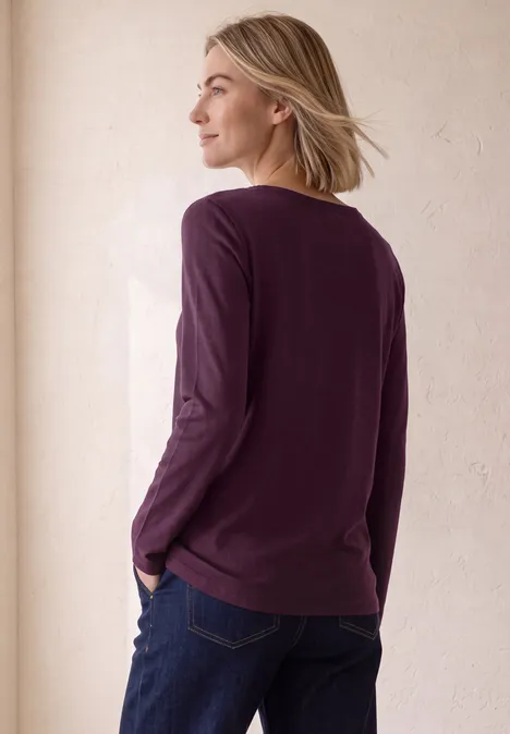 Langarm Shirt mit U-Boot-Ausschnitt berry maroon Frau mit lila Pullover blickt lächelnd zur Seite