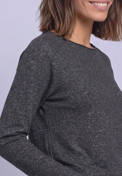 Close-up einer Person in dunkelgrauem, leicht strukturiertem Langarmshirt.