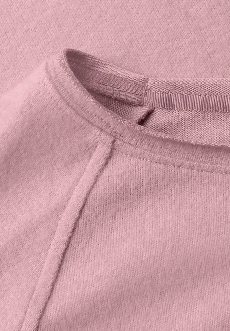 T-shirt à manches longues, col rond et bord roulé vintage blush mel. Nahaufnahme eines rosa Fleece-Oberteils mit sichtbarer Naht am Rundhalsausschnitt.