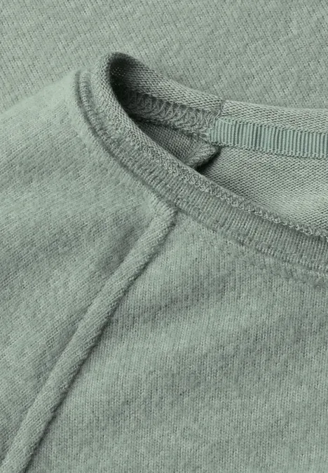 Nahaufnahme eines mintgrünen Shirts mit Rundhalsausschnitt und sichtbarer Naht.
