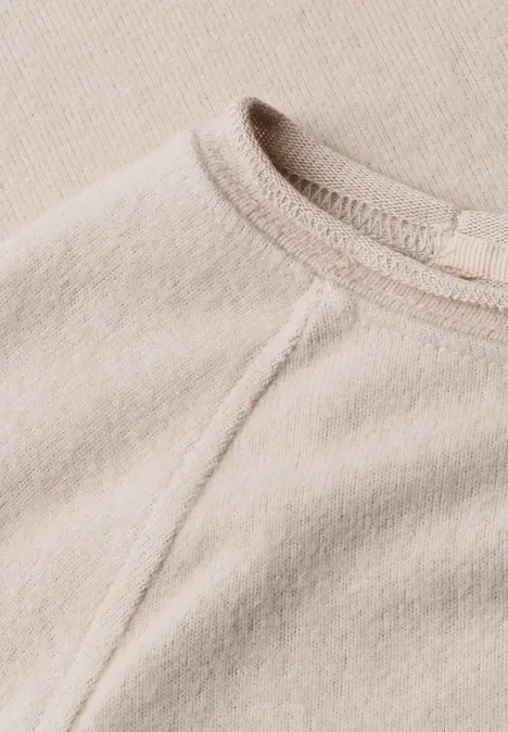 T-shirt à manches longues, col rond et bord roulé clay sand mel. Nahaufnahme eines beigen Pullovers aus weichem Stoff mit Rundhalsausschnitt und sichtbarer Naht.