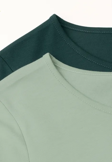 Twee effen T-shirts in lichtgroen en donkergroen, plat neergelegd met zichtbare ronde hals.