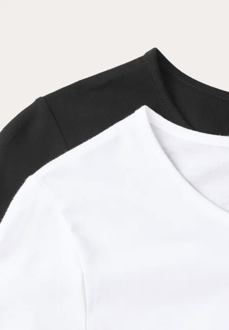Zwei schlichte T-Shirts (weiß und schwarz) vor hellem Hintergrund.