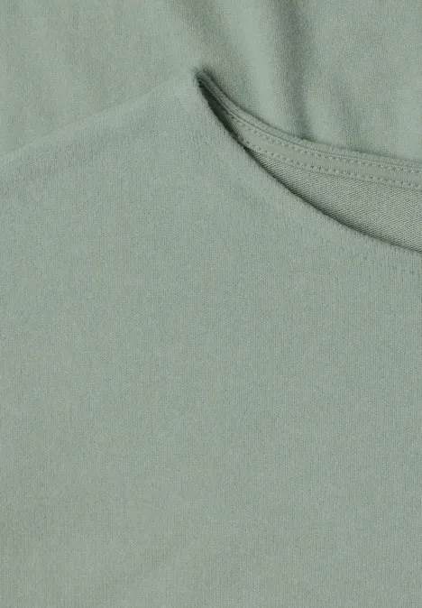 T-shirt à manches longues avec ourlet élastiqué eucalyptus green mel. Nahaufnahme eines hellgrünen T-Shirts mit Rundhalsausschnitt und feiner Stoffstruktur.