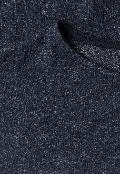 Gros plan d’un tissu tricoté gris foncé chiné avec une texture fine.