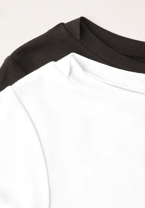 Zwei schlichte T-Shirts (weiß und schwarz) überlappen, Kragenausschnitt im Fokus.