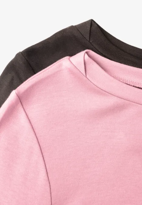 Zwei T-Shirts aus weichem Baumwollstoff, eines rosa, eines schwarz, leicht übereinander gelegt.