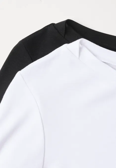 Zwei schlichte T-Shirts, eines weiß, eines schwarz, Nahaufnahme mit minimalistischem Design.