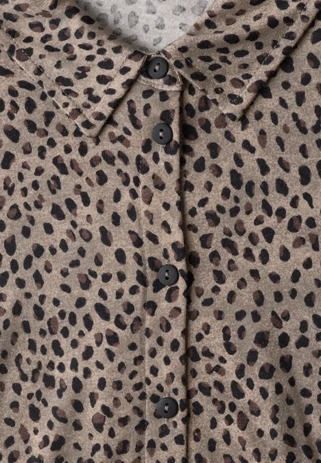 Beiges Hemd mit schwarzen, unregelmäßigen Leopardenflecken, Kragen und Knopfleiste.