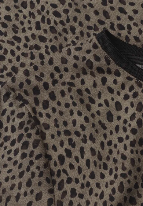 Gros plan sur un tissu beige-brun à motif léopard noir et encolure noire.