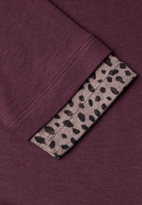 T-shirt à manches longues avec effet color block et imprimé rustic rouge Bordeauxrotes Textil mit einem beigen Label, das schwarze, unregelmäßige Punkte zeigt.