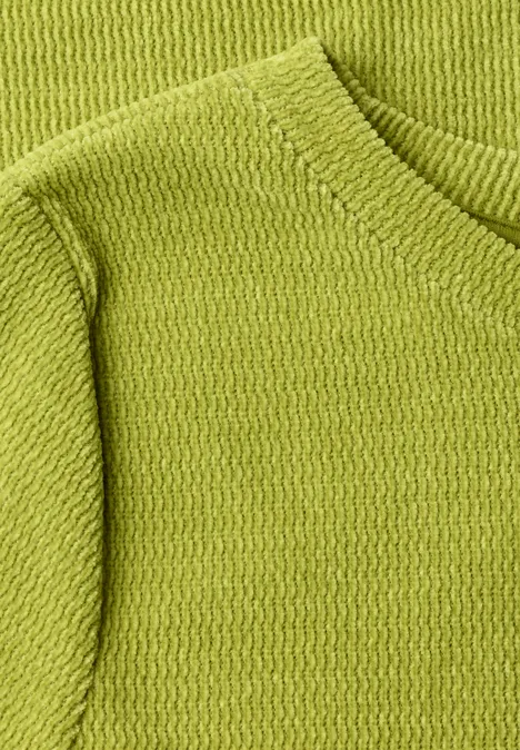 Nahaufnahme eines hellgrünen Strickpullovers mit feiner Textur