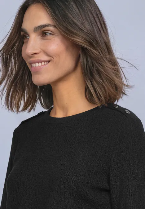 Langarm Shirt mit Struktur und Knöpfen Black Eine lächelnde Frau mit braunen Haaren in einem schwarzen Pullover vor hellem Hintergrund.