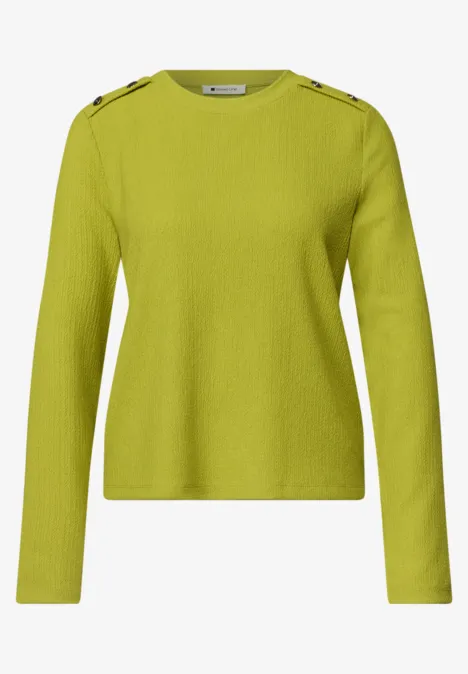 Langärmliger, hellgrüner Pullover mit Knopfdetails an den Schultern.