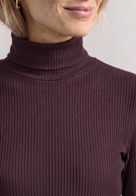 T-shirt basique uni à col roulé berry plum Vorderansicht eines dunkelvioletten, fein gerippten Rollkragen-Pullovers am Oberkörper einer Frau.