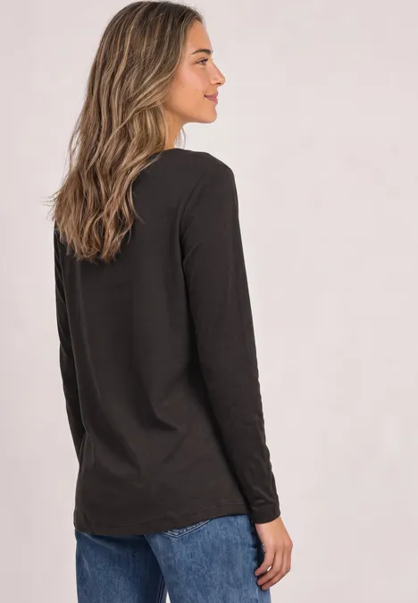 Basic Shirt mit U-Boot-Ausschnitt black coffee Frau steht seitlich, trägt schwarzes Langarmshirt und Jeans vor hellem Hintergrund.