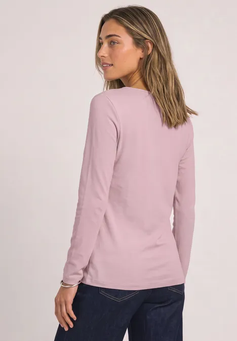 Basic shirt met boothals quiet rose Eine Frau mit langärmligem, rosafarbenem Shirt, von hinten, Kopf leicht zur Seite gedreht.