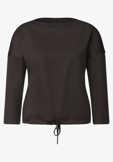 Zwart shirt met lange mouwen, boothals en koordje aan de onderkant.