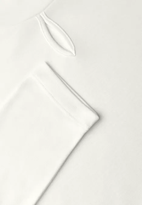 Schlichtes weißes Langarmshirt vor weißem Hintergrund.
