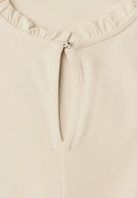 Basic Shirt mit Rüschen und Cut-Out-Detail pure beige Nahaufnahme eines cremefarbenen Oberteils mit Rüschen am Rundhals und kleinem Schlitz mit Metallverschluss.
