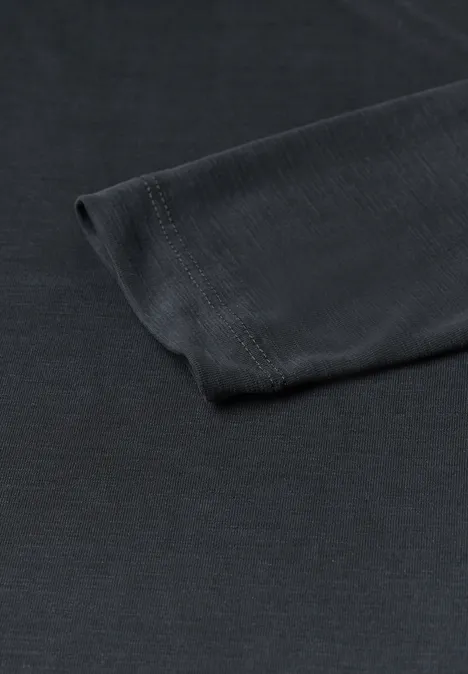 Nahaufnahme eines schwarzen Langarm-T-Shirts liegt flach auf weißem Hintergrund.