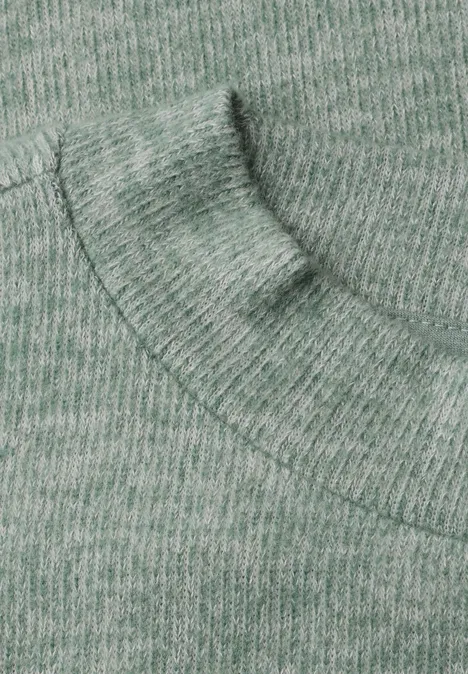 Close-up van een groene gebreide trui met capuchon