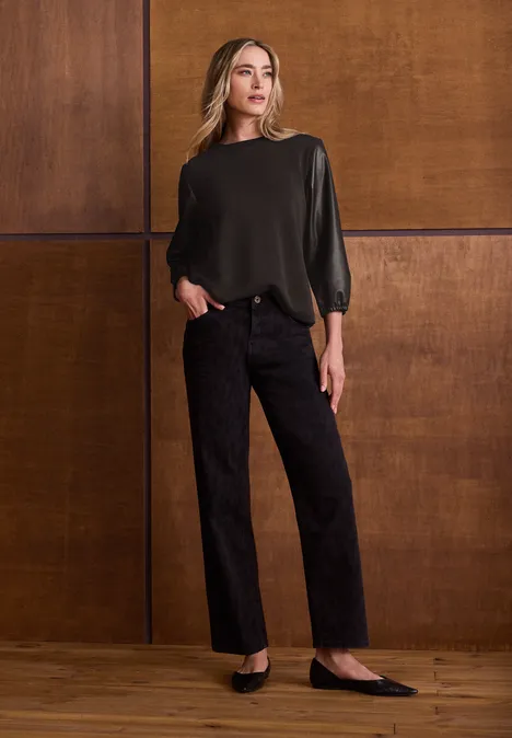 Shirt mit 3/4-Ärmeln in Leder-Optik black coffee Eine Frau steht vor Holzwand, trägt olivgrünes Oberteil, schwarze Hose und flache Schuhe.