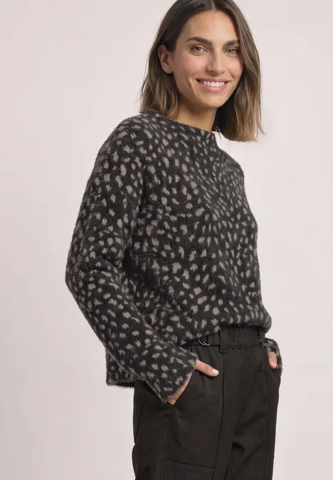 Langarm Shirt mit Turtle Neck und Muster black coffee Lächelnde Frau in dunklem, gemustertem Pullover und schwarzer Hose vor hellem Hintergrund.
