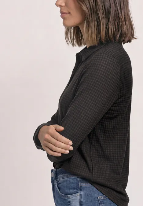 Jersey-Shirt met lange mouwen in blouse-stijl black coffee Seitlich aufgenommene Frau im schwarzen, gemusterten Oberteil mit verschränkten Armen.