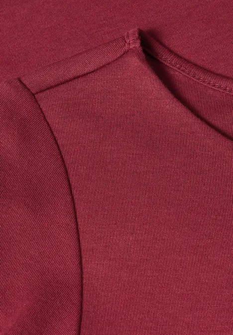 Nahaufnahme eines burgunderroten ärmellosen Oberteils aus weichem Jersey.