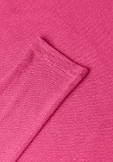 Nahaufnahme eines pinkfarbenen Baumwollgewebes mit einer sauber vernähten Kante.