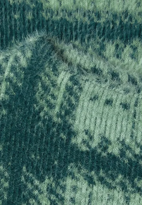 Grüner Strickstoff mit helleren, zigzagförmigen Fair-Isle-Mustern.