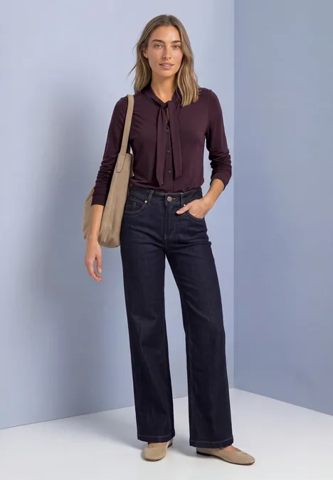 Langarm Shirt im Blusen-Look berry plum Modische Frau trägt weinrote Bluse, hohe Jeans und Tasche vor hellgrauem Hintergrund.