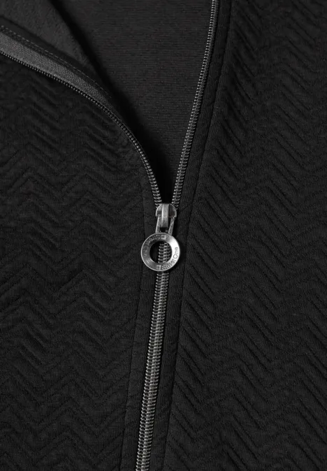Leichte Sweatjacke mit Struktur und Zipper Black Nahaufnahme eines schwarzen Reißverschlusses mit rundem Ring an strukturiertem Zickzack-Stoff.