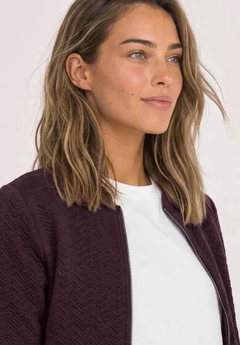 Leichte Sweatjacke mit Struktur und Zipper berry plum Junge Frau mit weißem T-Shirt und dunkelrotem Blazer blickt zur Seite.