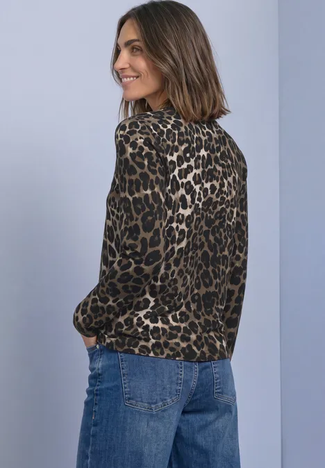 Langarm Shirt mit Rundhals und Leo-Muster Black Lächelnde Frau mit schulterlangem Haar trägt Leoprintbluse mit langen Ärmeln und Jeans vor grauem Hintergrund.